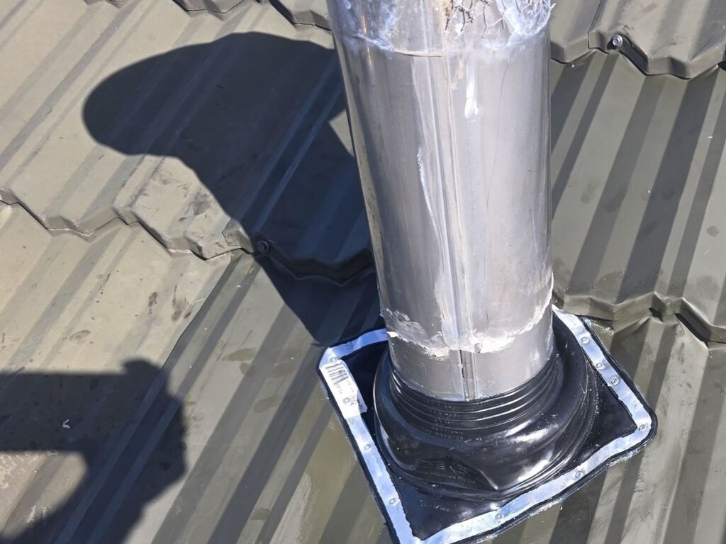 New flue boot and flashing plate on the metal tile roof