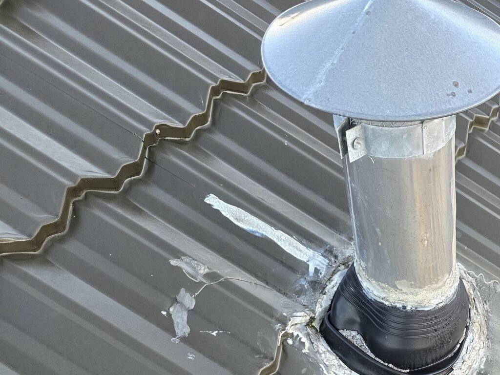 Split silicone seal around a flue on a metal tile roof